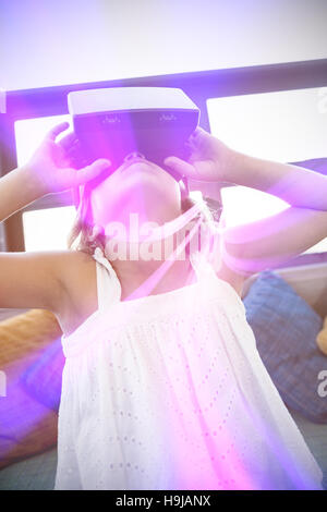 Elementary girl looking through virtual reality headset in school library Stock Photo