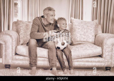 Father and son watching football match on tv Stock Photo