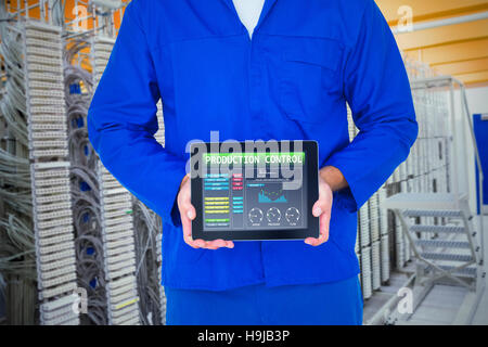 Composite image of smiling male mechanic showing digital tablet Stock Photo