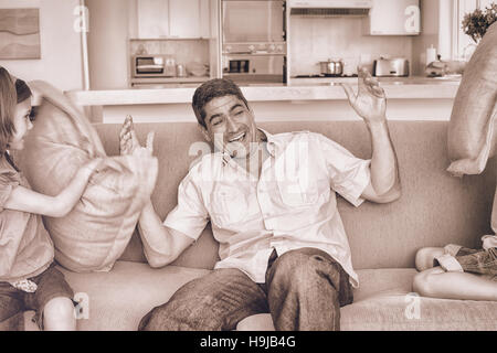 Family having pillow fight on sofa Stock Photo