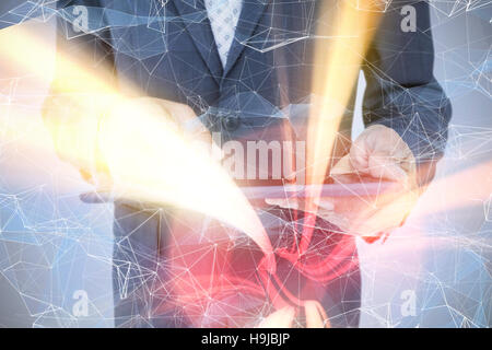 Composite image of  close up view of businessman using tablet computer Stock Photo