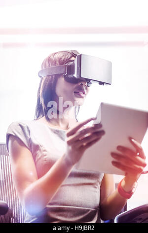 Businesswoman looking her tablet while using a virtual glasses Stock Photo