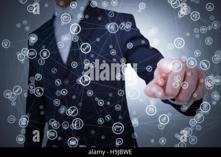 Composite image of smiling businessman in suit pointing Stock Photo