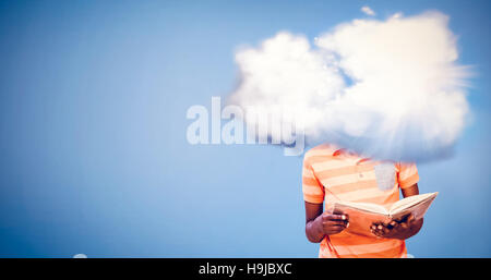 Composite image of cute boy reading book in library Stock Photo