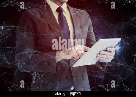 Composite image of businessman using his tablet pc Stock Photo