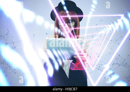 Composite image of smiling hipster woman using her tablet Stock Photo