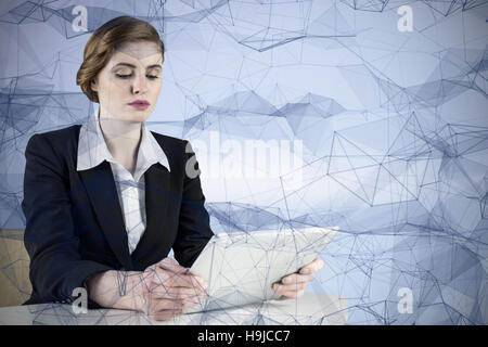 Composite image of redhead businesswoman using her tablet pc Stock Photo