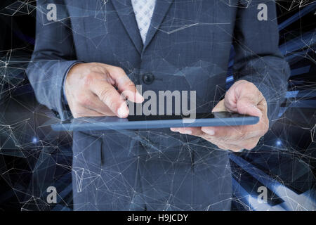 Composite image of  close up view of businessman using tablet computer Stock Photo