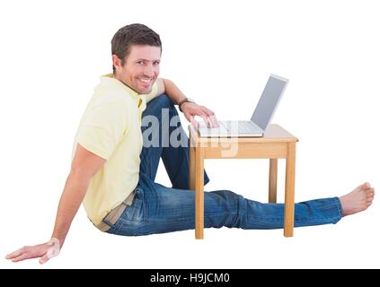 Smiling man using a laptop Stock Photo