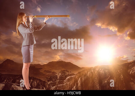 Composite image of businesswoman looking through a telescope Stock Photo