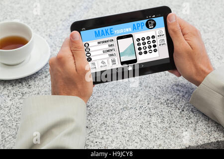 Composite image of businessman holding small tablet at table Stock Photo