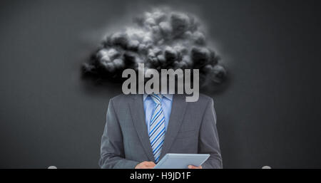 Composite image of businessman using a tablet  with colleagues behind in office Stock Photo