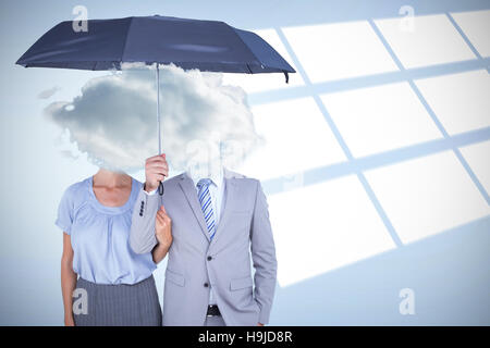 Composite image of business people holding a black umbrella Stock Photo