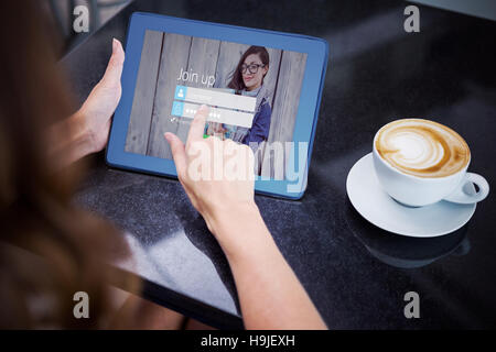 Composite image of woman having coffee and using her tablet Stock Photo