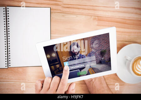 Composite image of login screen superimposed on hipster man with laptop Stock Photo