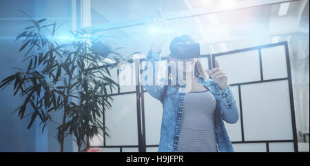 Businesswoman gesturing while using virtual reality headset Stock Photo