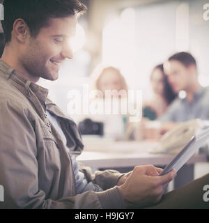 Smiling young man using digital tablet Stock Photo