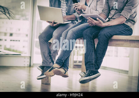 Three creative business team working on electronic devices Stock Photo