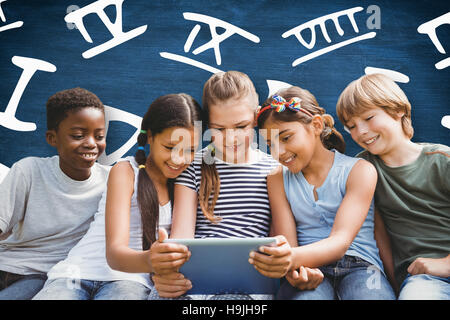 Composite image of children using digital tablet at park Stock Photo