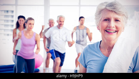 Senior woman with people exercising in fitness studio Stock Photo