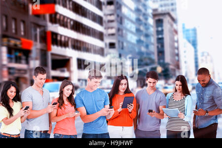 Composite image of four friends standing to the side slightly sending texts Stock Photo