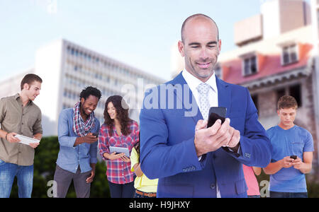 Composite image of smiling businessman using mobile phone Stock Photo