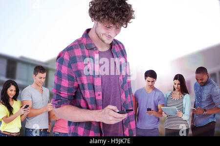 Composite image of smiling handsome man using mobile phone Stock Photo