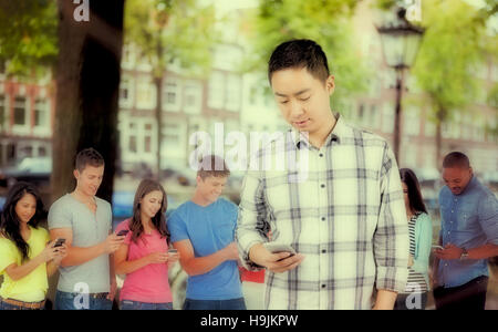 Composite image of young man using smart phone Stock Photo