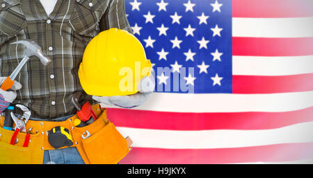 Composite image of manual worker wearing tool belt while holding hammer and helmet Stock Photo