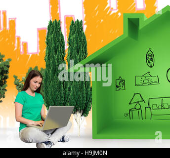 Composite image of student sitting on floor in library using laptop Stock Photo