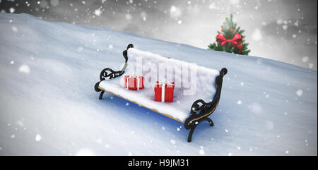 Composite image of snow covered bench with gift boxes Stock Photo