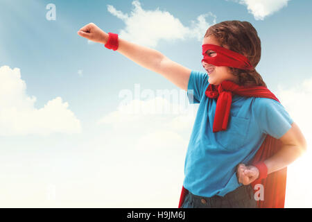 Composite image of happy boy in red cape Stock Photo