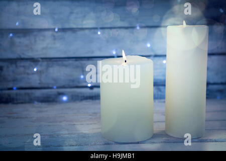 Candles burning on wooden plank Stock Photo