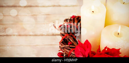 Candles decorated with flowers nest basket on wooden plank Stock Photo