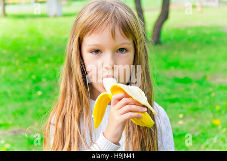 Photo of girl are eating banana in summer Stock Photo