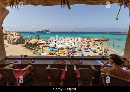 Spain, Balearic Island, Ibiza, Cala Comte beach, woman sitting at the cafe Stock Photo