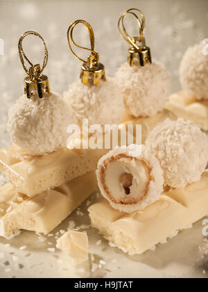 Round small candies like Christmas decorations on tiles of white chocolate Stock Photo