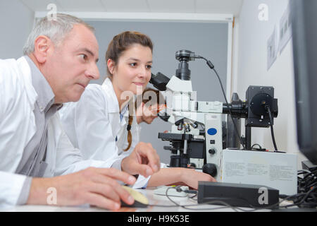 medical students and teacher working with microscope at the university Stock Photo