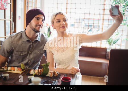 Couple taking selfie while having sushi Stock Photo