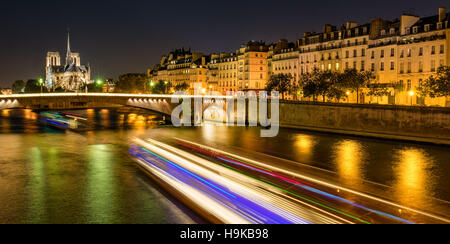 Notre Dame de Paris cathedral illuminated with the Seine River and the Tournelle Bridge. Ile Saint Louis, Paris, France Stock Photo