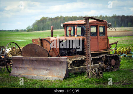 Old rusty crawler tractor with shovel Stock Photo