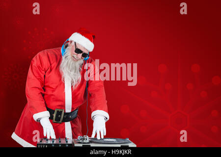 Composite image of santa claus playing dj Stock Photo