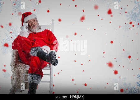 Composite image of excited santa claus talking on mobile phone Stock Photo
