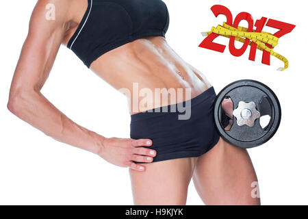 3D Composite image of female bodybuilder holding large black dumbbell mid section Stock Photo