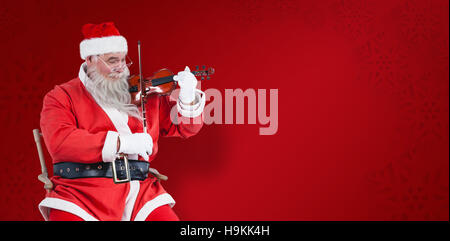 Composite image of smiling santa claus playing violin on chair Stock Photo