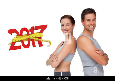 3D Composite image of portrait of a happy fit young couple with hands crossed Stock Photo