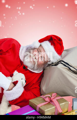 Composite image of high angle view of santa claus sleeping beside christmas presents Stock Photo