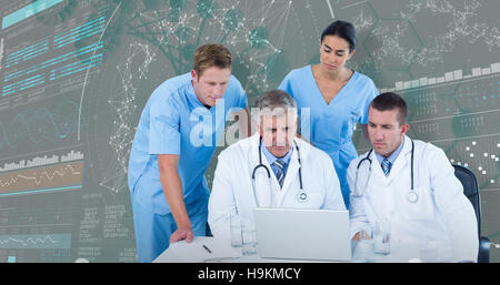 3DComposite image of team of doctors using laptop at desk Stock Photo