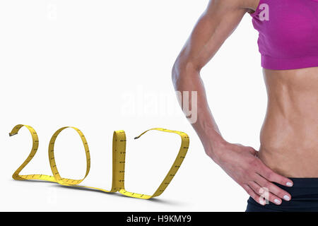 3D Composite image of female bodybuilder posing with hands on hips mid section Stock Photo