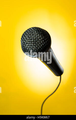 portrait of a black microphone in yellow background Stock Photo